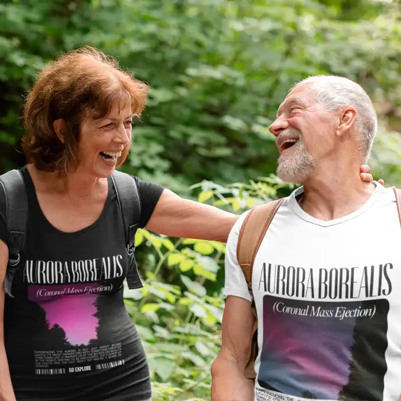 Two people wearing matching ’Aurora Borealis’ t-shirts share a joyful laugh together.