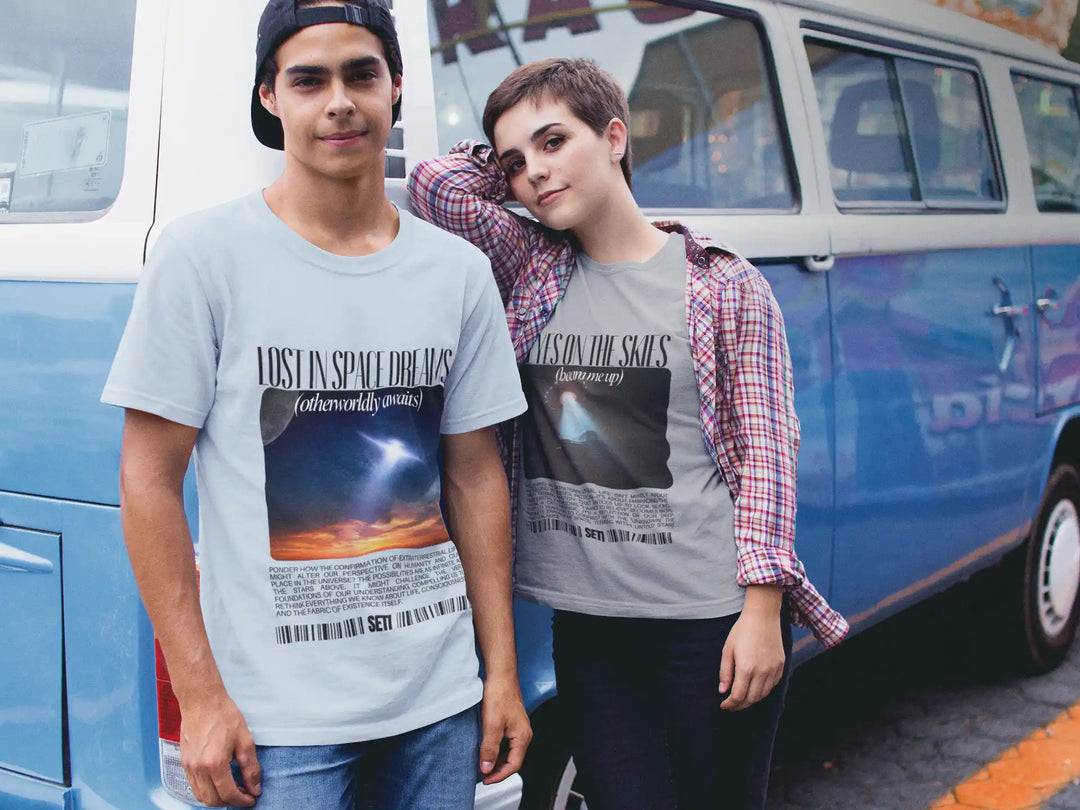 Two people wearing graphic t-shirts standing in front of a blue van.